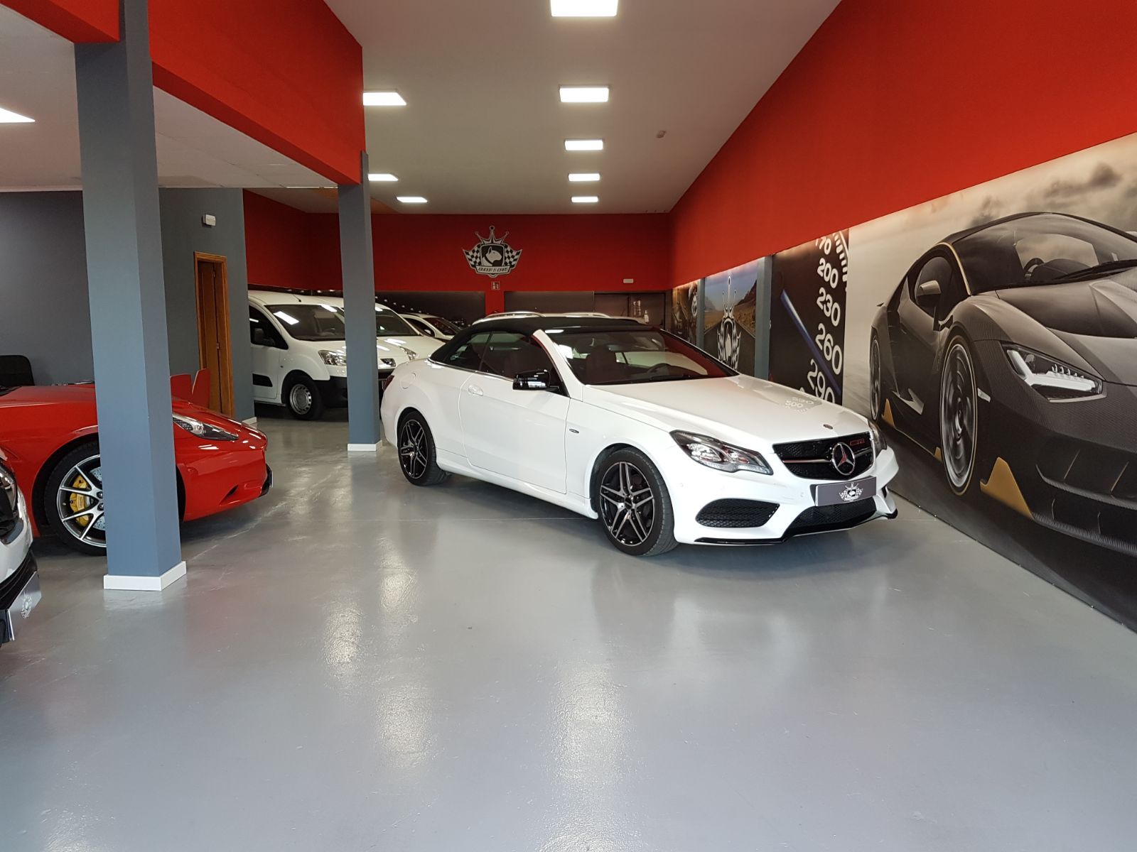 Interior del concesionario Queens Cars con vehículos de lujo